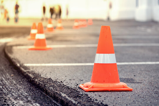 road repairs Multiple orange traffic cones placed in a line on an asphalt street, indicating roadwork or caution area.