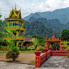 Naklejka premium Traditional lao temple stairs and mountain background near Vang Vieng, Laos 
