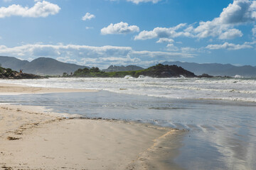 Fototapeta premium Coastline with rocks, beach and ocean with waves in Brazil. Matadeiro Beach in Florianopolis