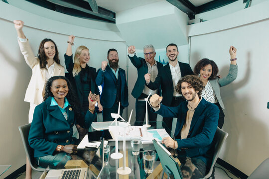 Happy business team celebrating successful green energy project in modern office
