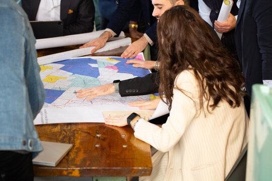 Architects and surveyors studying cadastral map on a table
