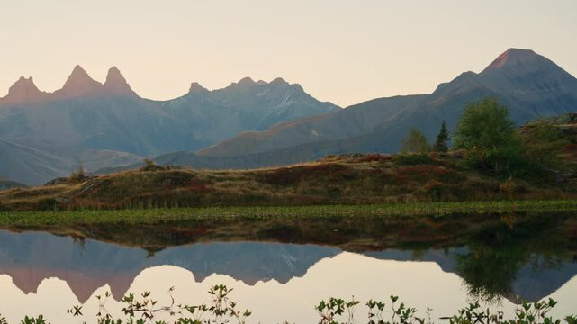 Landscape of sunrise over Lac Guichard with Arves massif and lake reflection in autumn at France