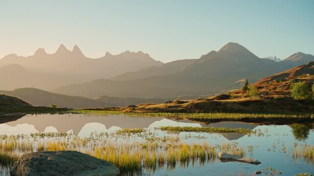 Landscape of sunrise over Lac Guichard with Arves massif and lake reflection in autumn at France