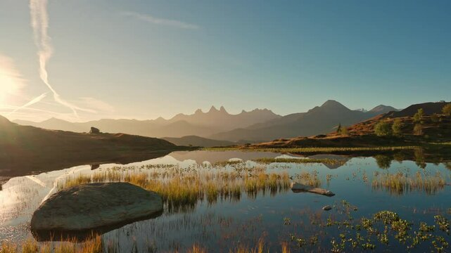 Landscape of sunrise over Lac Guichard with Arves massif and lake reflection in autumn at France