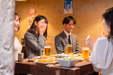 飲み会で大爆笑して盛り上がる会社員の女性