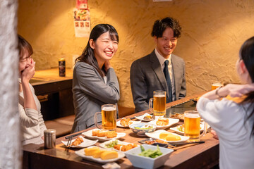 飲み会で大爆笑して盛り上がる会社員の女性