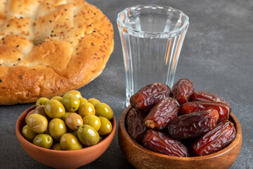 Dates fruit, green olives, Ramadan pita, and water for the iftar table