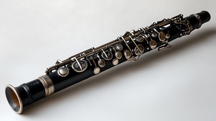 Fototapeta premium Black and silver clarinet placed diagonally on a clean white background showcasing its glossy and textured details