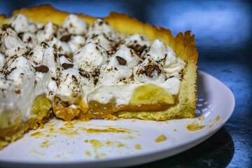 Traditional banoffee cake with banana and caramel sauce filling sprinkled with grated dark chocolate and coffee . English traditional pie