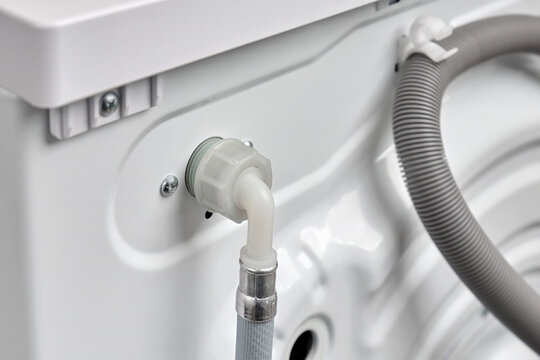 Top view  of a hose for connecting cold water to a washing machine in a house or apartment. Washer on back side.