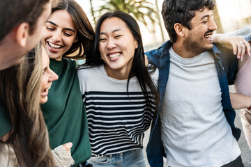 Multiethnic friends having fun walking on city street - Group of young people enjoying summer vacation together - Friendship concept with guys and girls hanging outside on a sunny day