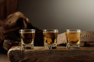 Whiskey shots on a old wooden board.