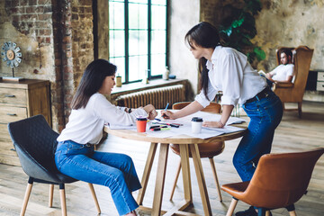 Casual young women discussing project in loft office