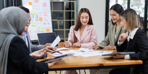 Business Asian people, laptop and conversation with research, teamwork and connection in the office. Group, employees and accounting with computer, internet and cooperation with meeting and planning