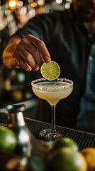 Bartender garnishes Margarita with a fresh lime slice at a lively bar