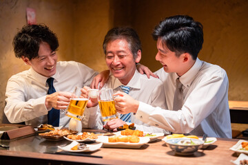 上司と肩を組みながら居酒屋で飲むサラリーマン