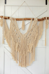 Wall panel in style of Boho made of cotton threads using the macrame technique for home decor and wedding decoration. Cozy Home decor concept. White Macrame in living room with boho interior design	
