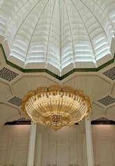 Close-up of the gold chandelier hanging from the ceiling of the prayer hall of the Great Mosque of...