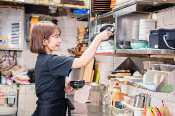 居酒屋の厨房で働くキッチンスタッフの女性