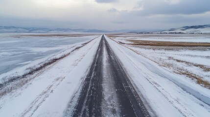 Obraz premium A snowy road stretches through a winter landscape.