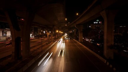Timelapse of traffic at night with the movement of car tail lights in Bangkok, Thailand. Urban transportation lifestyle.