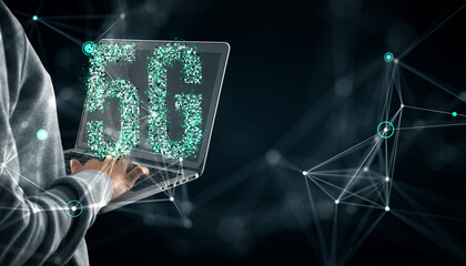 5G holographic digital sign displayed on laptop held by a person, representing modern communication and technology concept.