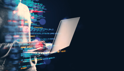 Person using a laptop with programming code overlay on a dark background.
