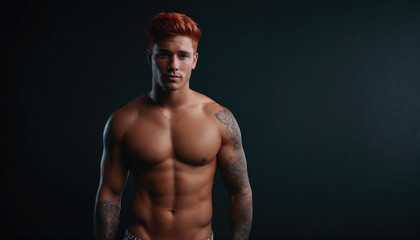 Fototapeta premium Muscular man posing confidently in a studio with dramatic lighting showcasing his tattoos and physique
