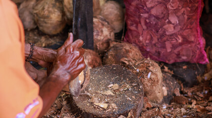 Close up Hand old man peeling coconuts at a traditional market with machete