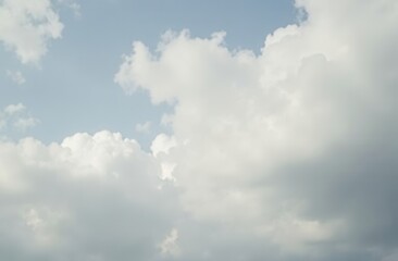 Obraz premium A clear, blue sky adorned with fluffy, white clouds drifting in it