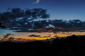 The end of the sunset fills the sky with the colors of an awesome  afterglow, over the western Andean mountains of central Colombia.