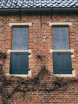 Detail of Monastery Windows Blinds of Historic Nijsinghhuis in Eelde with Greenery and Brick Wall