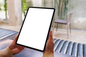 Mockup image of a woman holding digital tablet with blank desktop screen in cafe