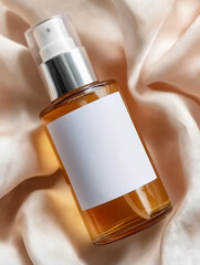 Naklejka premium Amber toner spray bottle with a white label and silver pump, placed on soft satin fabric, emphasizing luxurious and elegant skincare branding