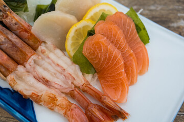 A beautifully arranged sashimi platter salmon, shrimp, and scallop. Top view