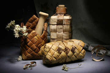 Birch bark products. Still life with a wicker bottle, napkin holder and pencil case.