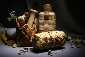 Birch bark products. Still life with a wicker bottle, napkin holder and pencil case.