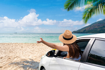 Young female tourist looking at the beautiful beach and sea view with car while travel driving road trip on summer vacation