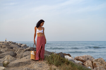 Young Woman Walking on Rocks by the Sea