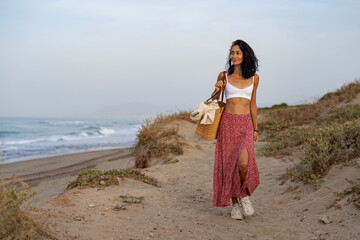 Young Woman Walking on a Sandy Path by the Beach