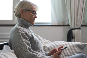 Senior woman browsing online stores on her smartphone