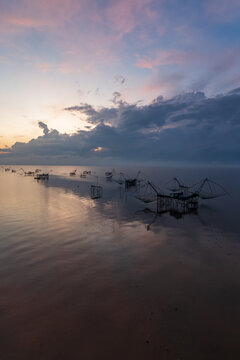 Silhouette of traditional fishing nets and platforms on Pak Pra river at sunrise, Phatthalung, Thailand