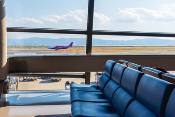 Airport terminal glass window with view of airplane, airport interior departure hall for travel and transportation concept.