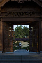A girl stands at a wooden gate to a Japanese garden. Krasnodar.