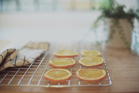Dried orange slices on a metal cooling rack on a kitchen worktop