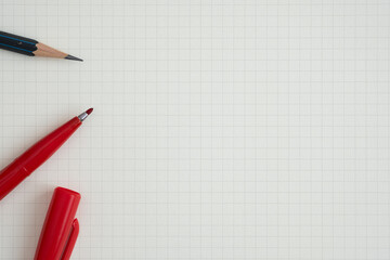 Top view, Close-up of Red Felt-tip Pen and Pencil on Graph Paper, Copy Space for Text, Flat Lay Concept.