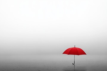 A striking red umbrella stands alone on a serene water surface, enveloped by a minimalist foggy backdrop.