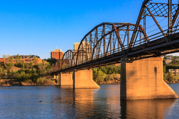 A bridge spans a river with a city in the background