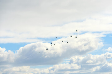 雲間を飛ぶヘリコプターの編隊