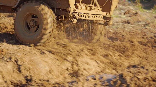 A close-up of a prepared SUV making its way through difficult terrain. All the wheels are skidding, scattering dirt. Extreme racing. Slow motion